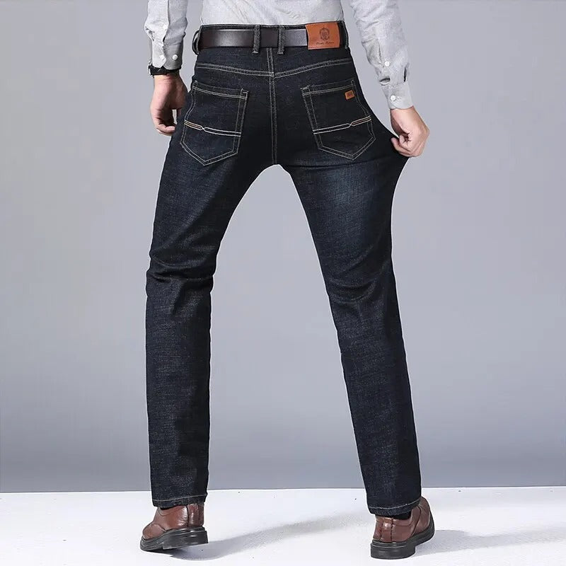 Mann i klassiske blå denimjeans med smal passform. Viser tidløs stil og komfortabel herremote.
