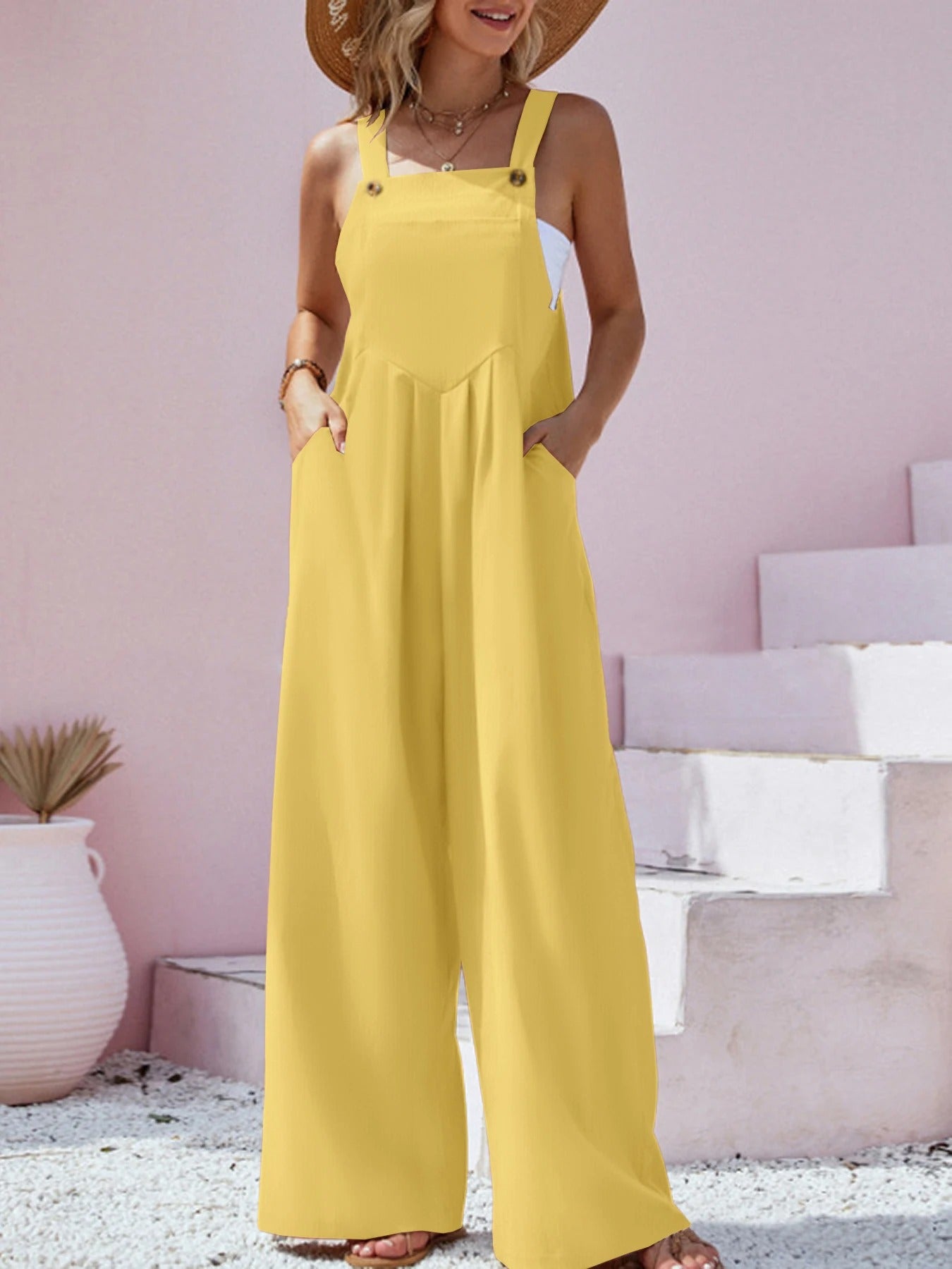 Stilig ensfarget dame jumpsuit med vide ben, løs passform og bukseseler for sommeren.