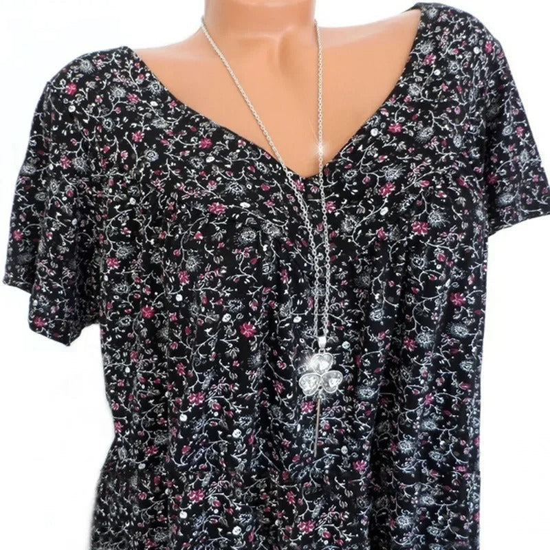 Dame tanktopp med v-hals og levende blomstertrykk, viser ledig passform. Komfortabel.