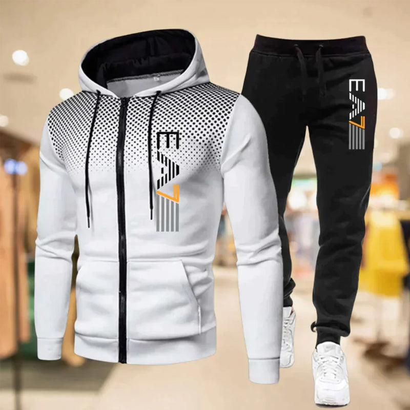 Mann poserer i moderne joggebuksesett med glidelås, perfekt for en sporty hverdagslook.