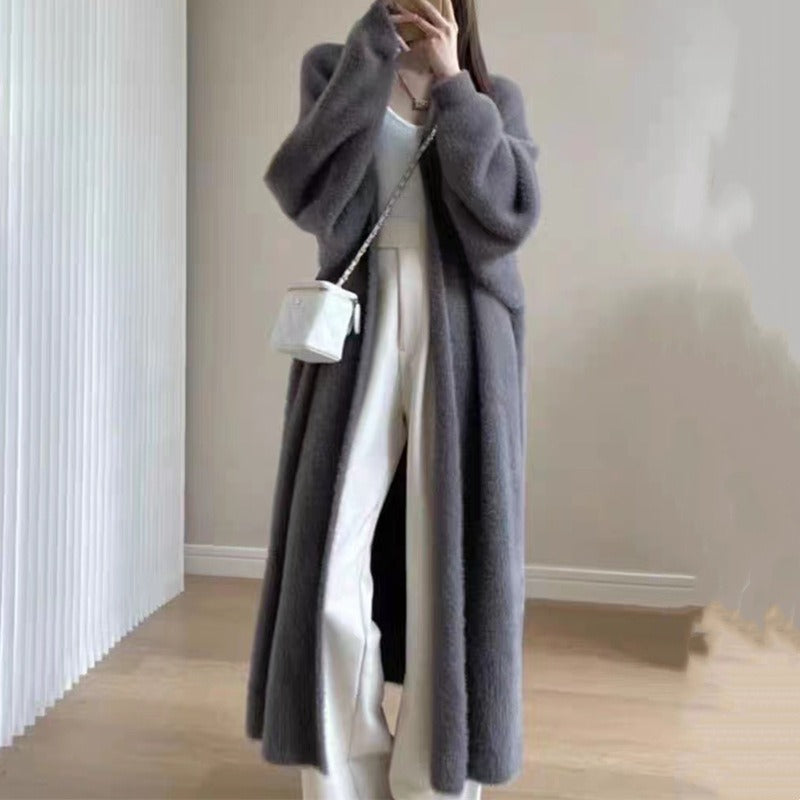 Kvinne nyter kaffe i en varm, oversized strikket cardigan. Avslappet og komfortabel hverdagsstil for høst.