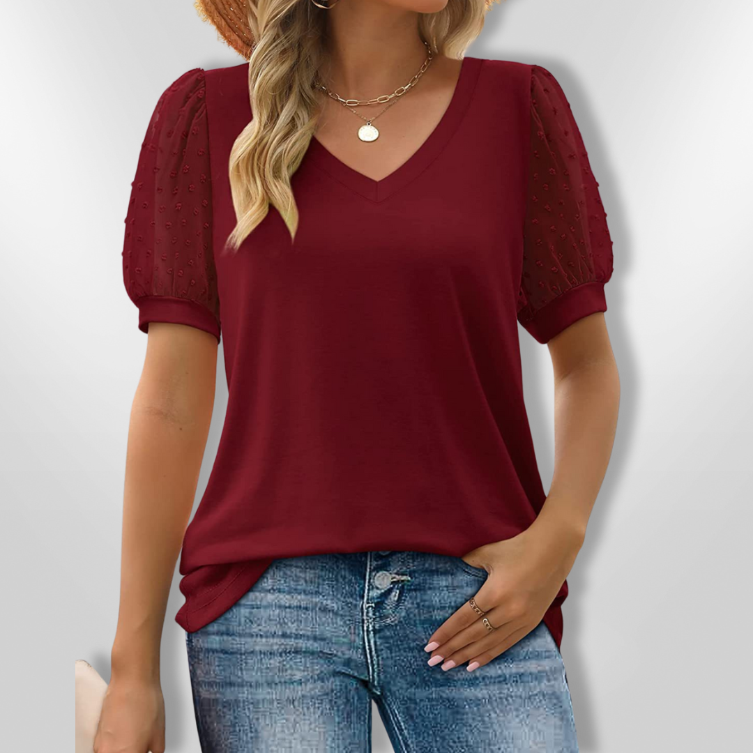 Moderne kvinnebluse med dyp V-hals og voluminøse puffermer, perfekt for en elegant look.
