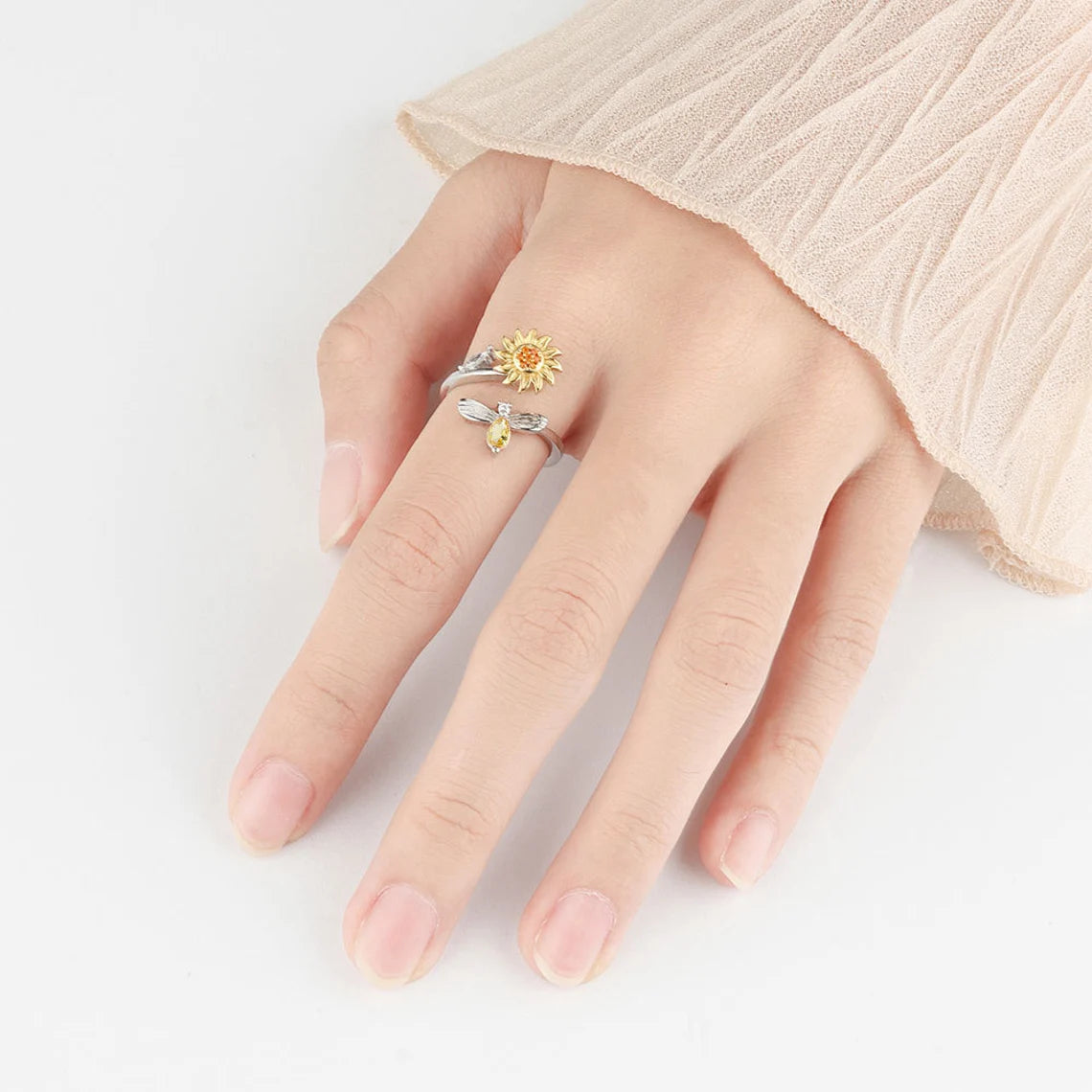 Kvinnehånd som viser justerbar solsikke fidget ring. Stilfull og funksjonell for daglig stresslindring.