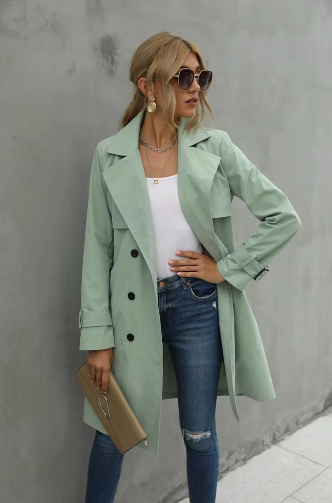Bakfra: Klassisk kvinners trenchcoat med belte, designet for en sofistikert silhuett. Ideell overgangsjakke.