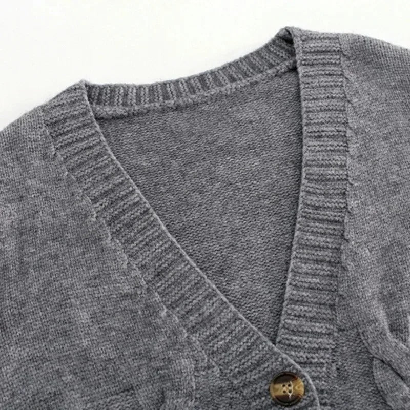 Kvinne iført moteriktig strikket V-hals cardigan i beige, med elegant og avslappet passform.
