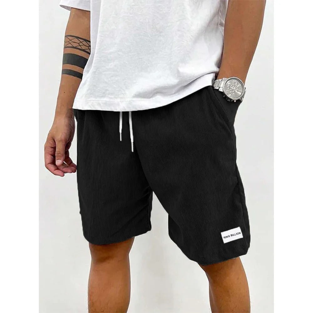 Mann trägt bequeme Herren Cord-Shorts in Grün, kombiniert mit einem T-Shirt im Sommer