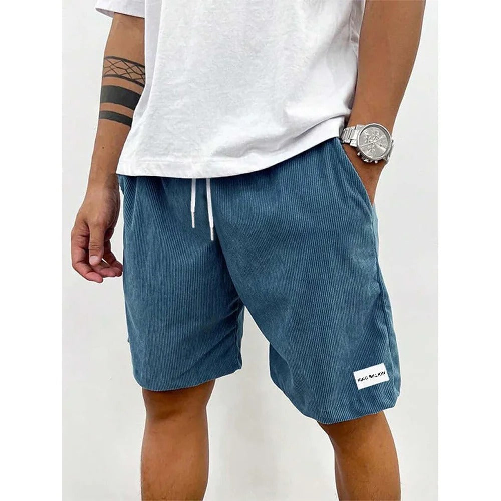 Herren Cord-Shorts in Grau auf einem Holztisch, zeigt den weichen Stoff und die lockere Passform