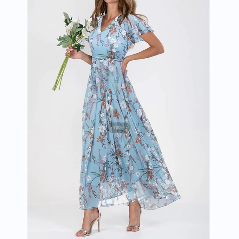 Nærbilde av blomstermotiv og sommerfuglermer på en vakker dame maxi kjole, viser detaljer og tekstur.
