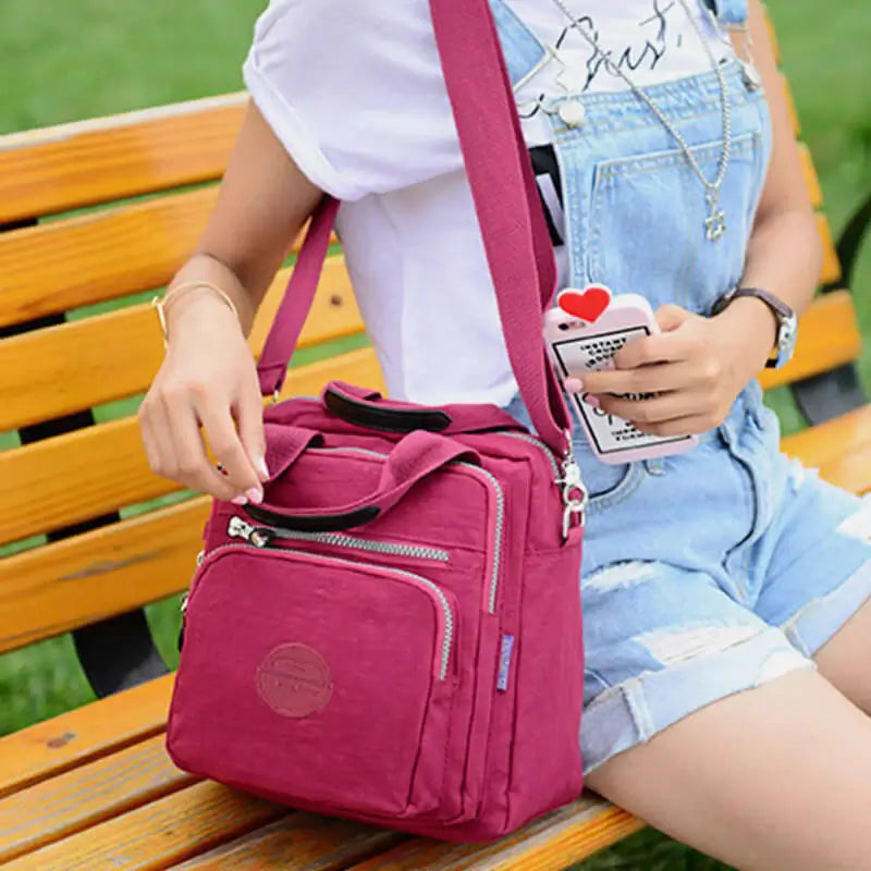 Enkel og elegant nylon crossbody-veske for kvinner, lett å bære over skulderen.