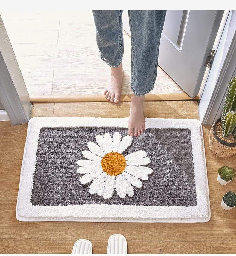 Komfortabel baderomsmatte med tusenfryd. Absorberende og myk for en behagelig opplevelse på badet.