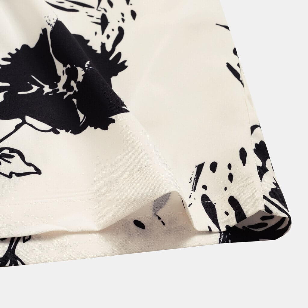 Bakside av menns luftige sommerbluse med blomsterprint. Lett og komfortabel beige/hvit hawaiiskjorte.