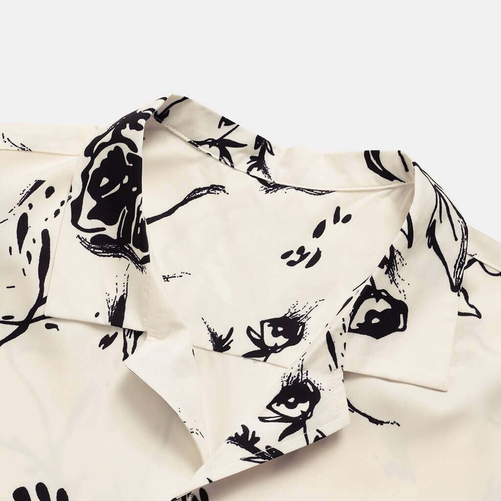 Reiseklar menns sommerbluse; lett blomstret hawaiiskjorte i beige/hvit. Komfortabel for varme og ferie.