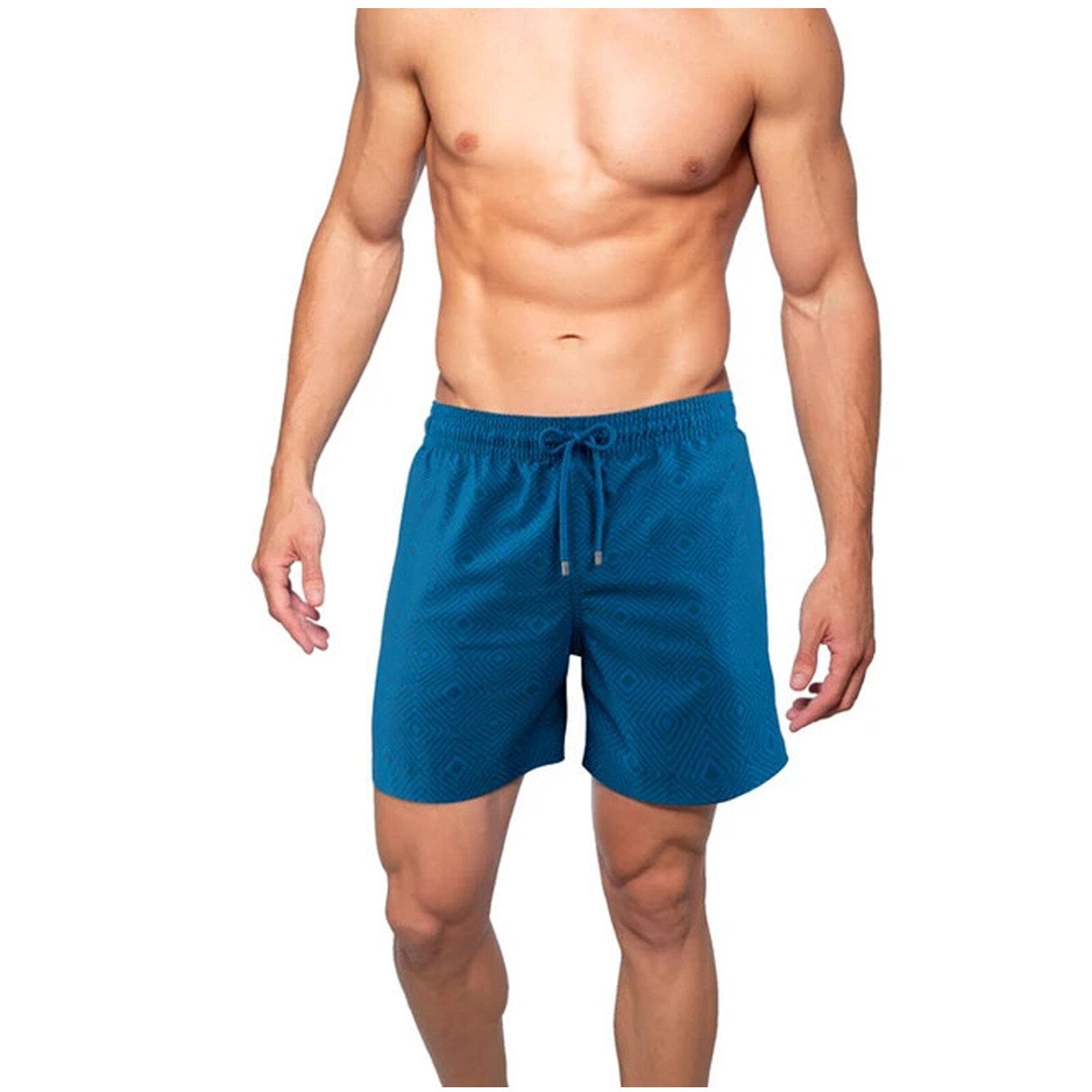 En mann løper på stranden iført blå hurtigtørkende badshorts med kompresjon og praktiske lommer.