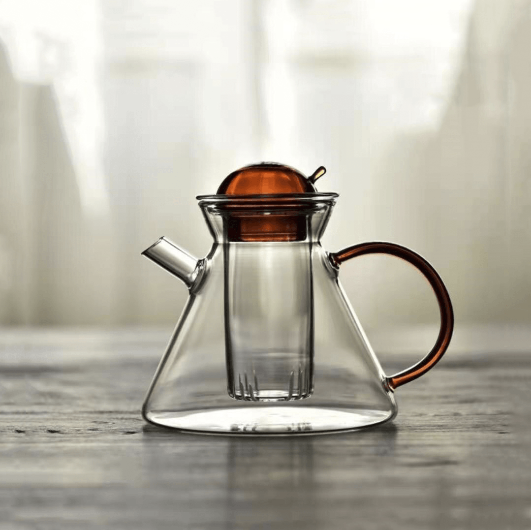 Borosilikatglass tekanne med innebygd filter for løs te, del av et minimalistisk nordisk te-sett.