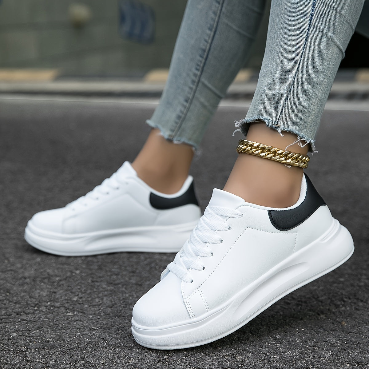 Detaljbilde av minimalistiske hvite damesneakers. Stilrene og komfortable kvinner sko.