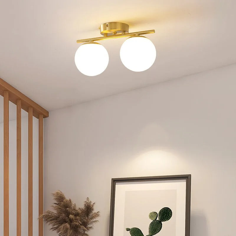 Nordisk inspirert glasskule taklampe med gullfinish, gir mykt lys til moderne soverom.