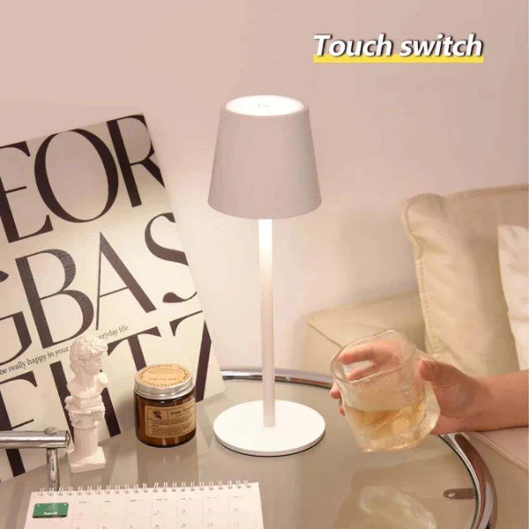 Oppladbar bordlampe i moderne design på nattbord, gir varmt LED-lys med enkel berøringskontroll.