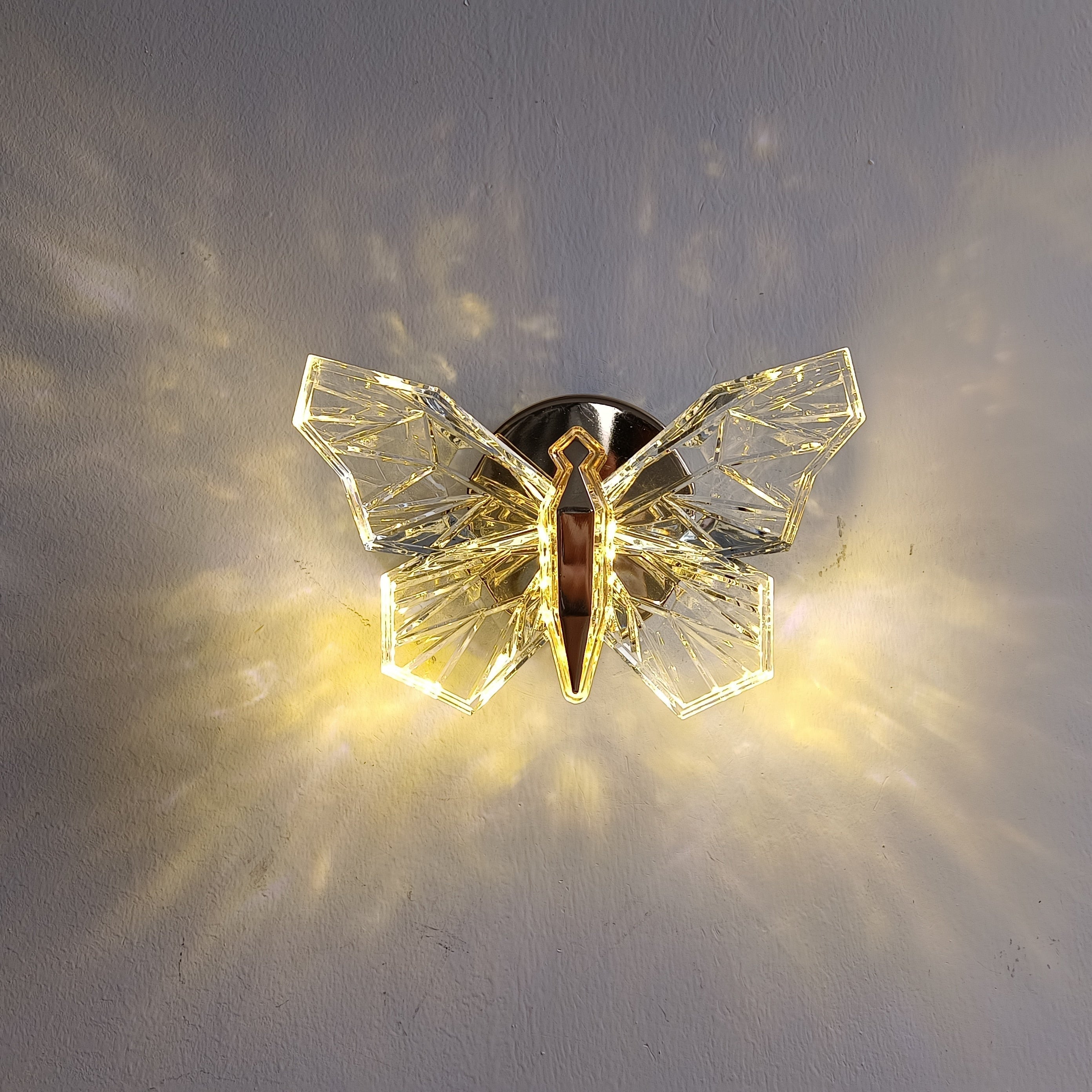 Skap atmosfære med Nordisk Sommerfugl LED vegglampe. Gullfarget belysning med varmt LED-lys.