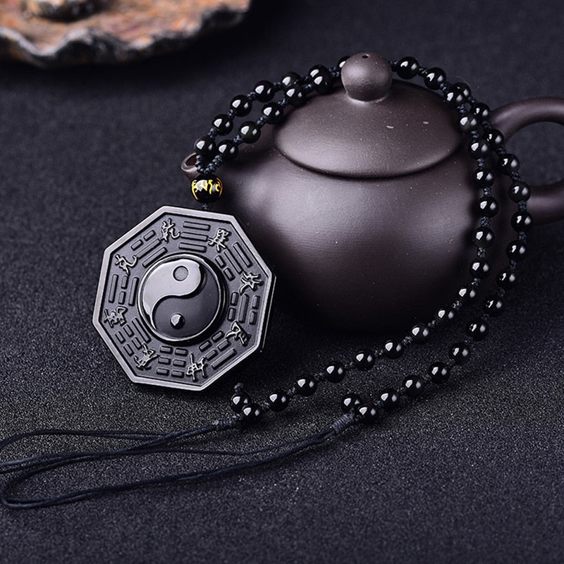 Nærbilde av glatt obsidian Yin Yang anheng. Symboliserer harmoni og åndelig energi.