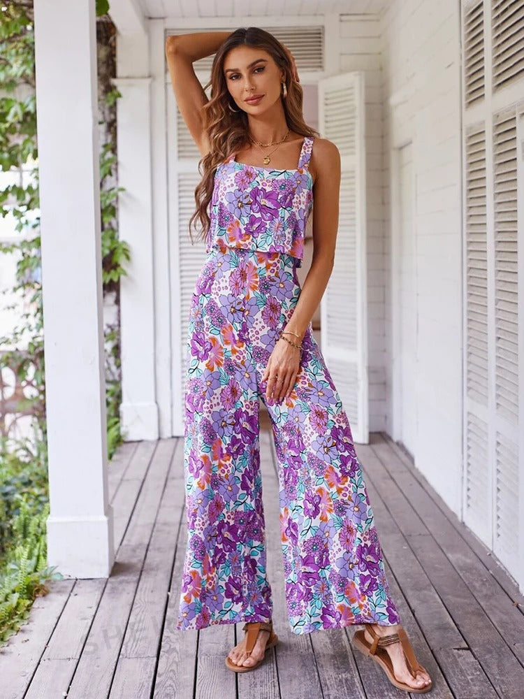 Dame iført oransje-lilla blomstret ryggløs jumpsuit, vide ben, elegant og avslappet sommerlook.