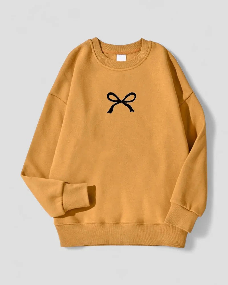 Stilfull oversized damegenser med feminin sløyfe. Myk bomullsblanding for optimal komfort og varme.