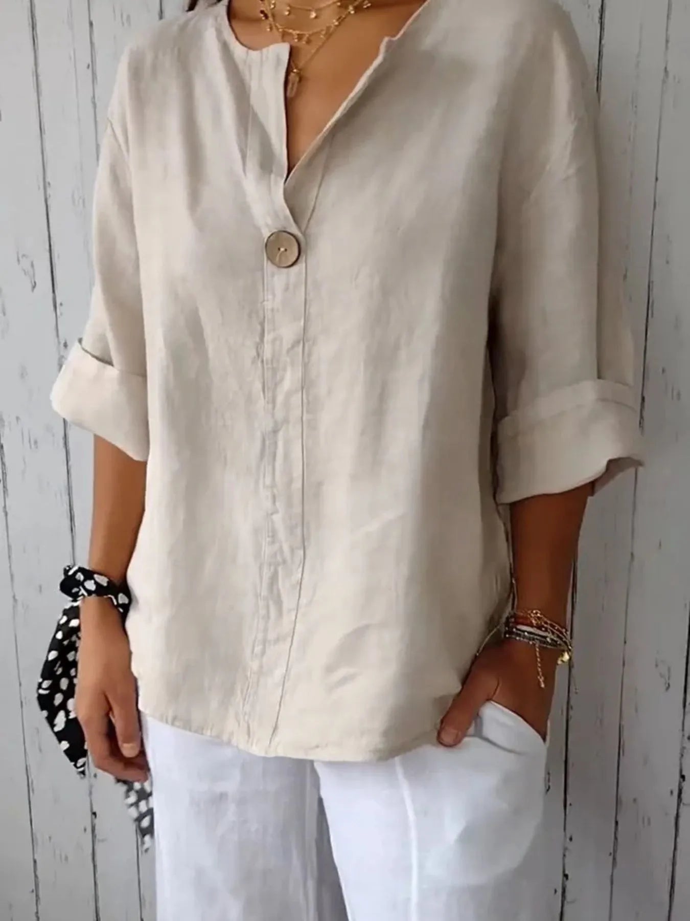 Modellen har på seg en hvit plus size bluse med notch detalj, stylet for en smart look.