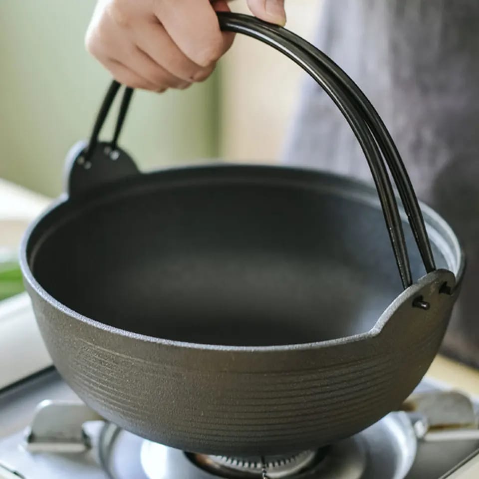 Robust støpejernswok med trelokk. Jevn varmefordeling sikrer optimal matlaging av dine favorittretter.