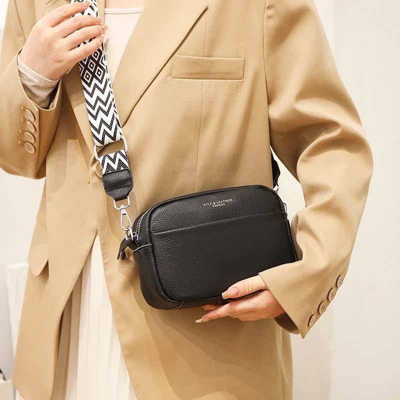 Kvinne bærer en svart elegant skulderveske/crossbody-veske, et stilig mote tilbehør til antrekket.