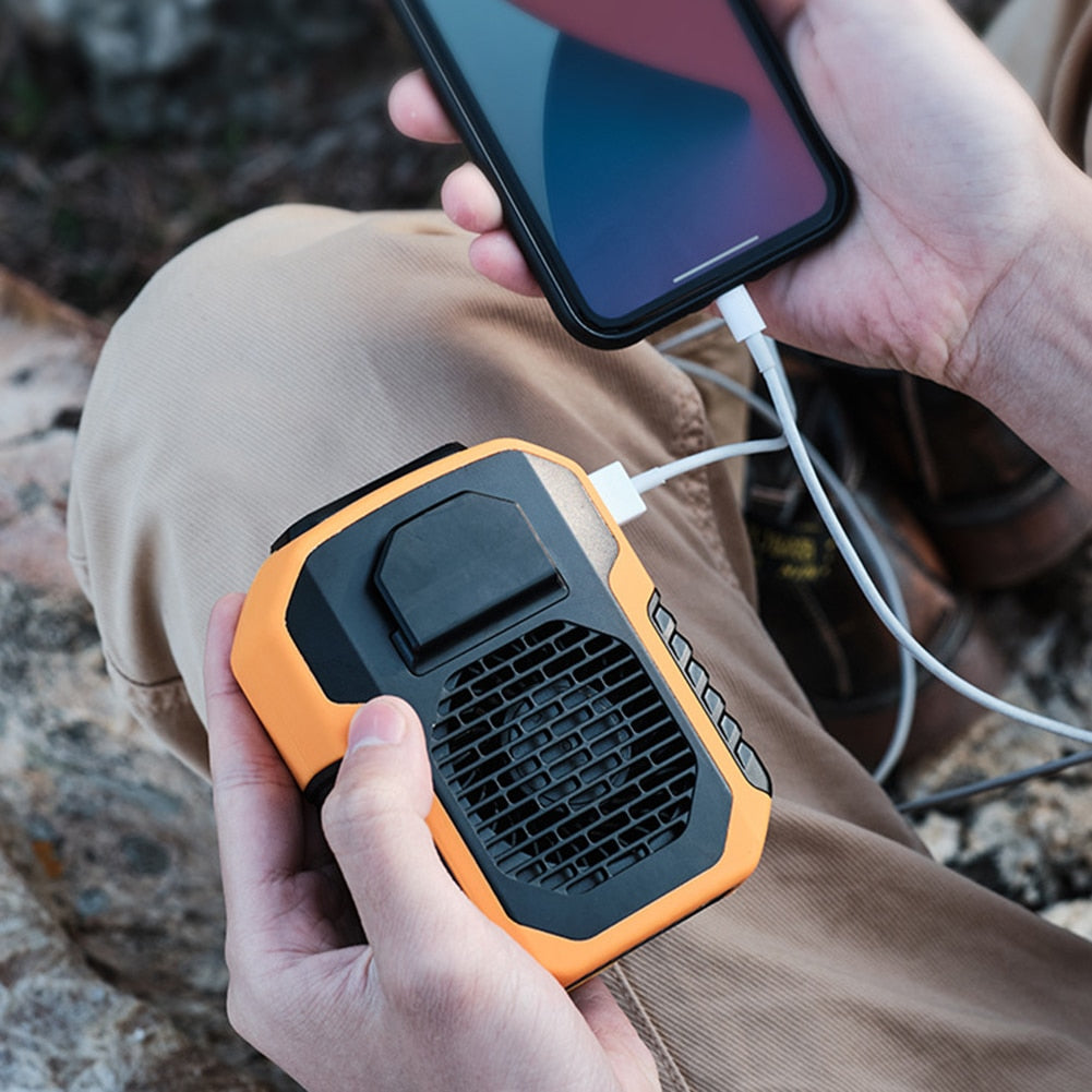 Kompakt oransje håndfri vifte med innebygd powerbank; perfekt for utendørs eventyr.