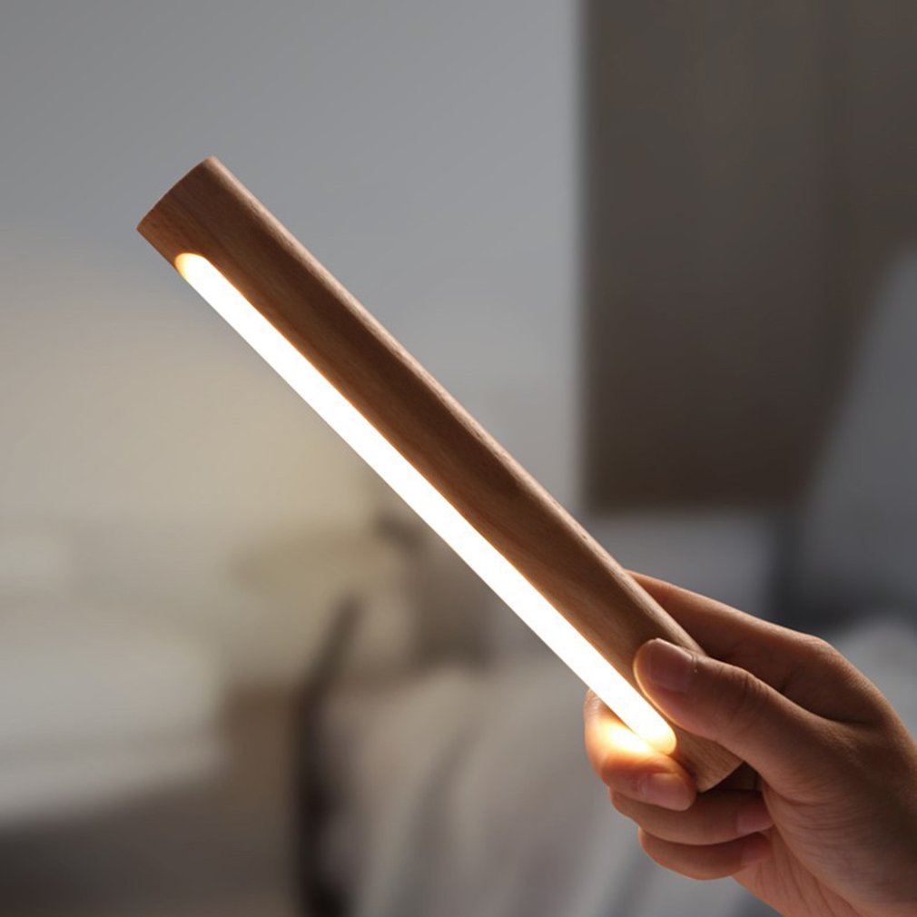 Elegant LED vegglampe i treverk, trådløs og oppladbar. Gir varmt leselys og koselig interiørdekor.