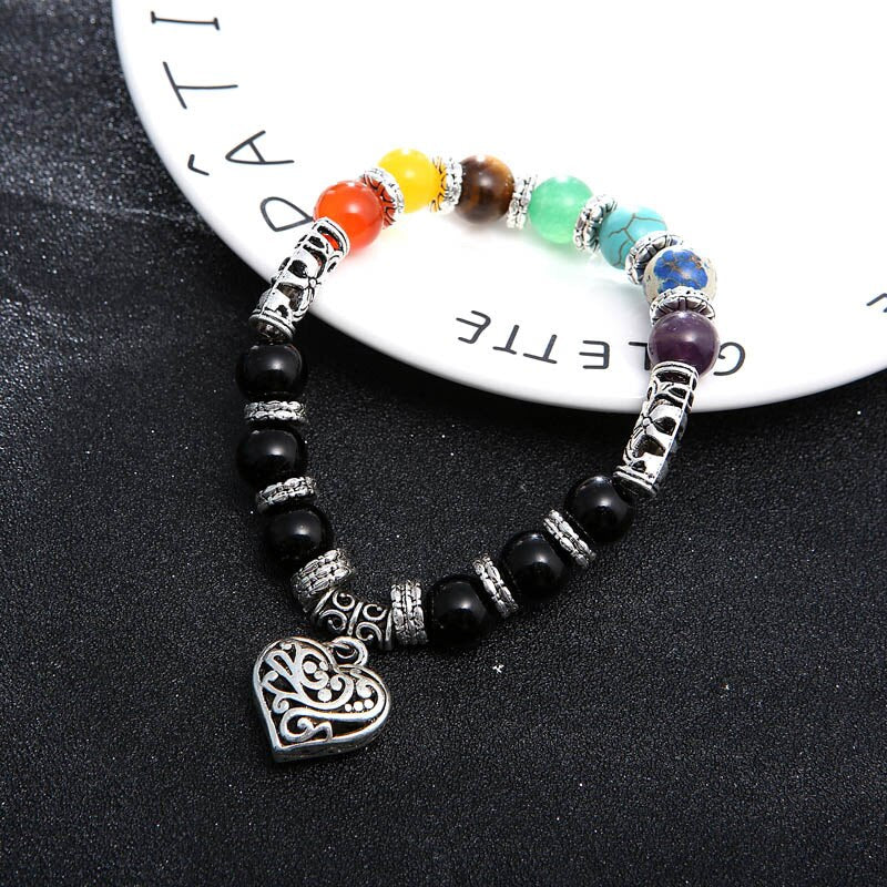 Unisex steinarmbånd med 7 chakra edelstener, båret på et håndledd. Fremmer helse og indre balanse.