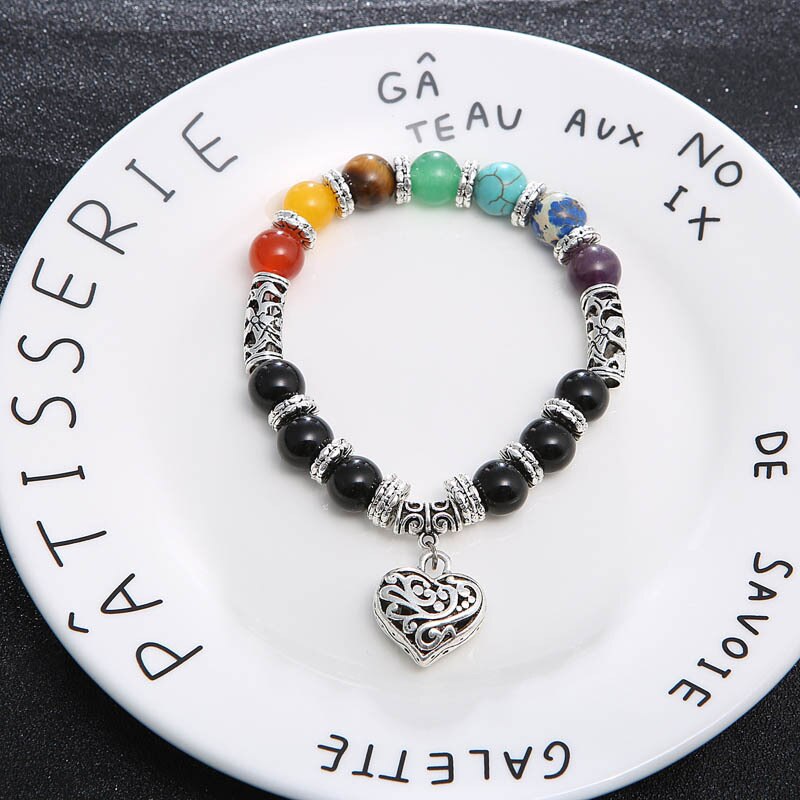 Detaljer av polerte 7 chakra steiner i et unisex armbånd, kjent for sine helse- og energifremmende egenskaper.