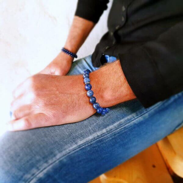 Lavastein armbånd på et kvinnelig håndledd. Unisex smykke med rå energi og unik tekstur.