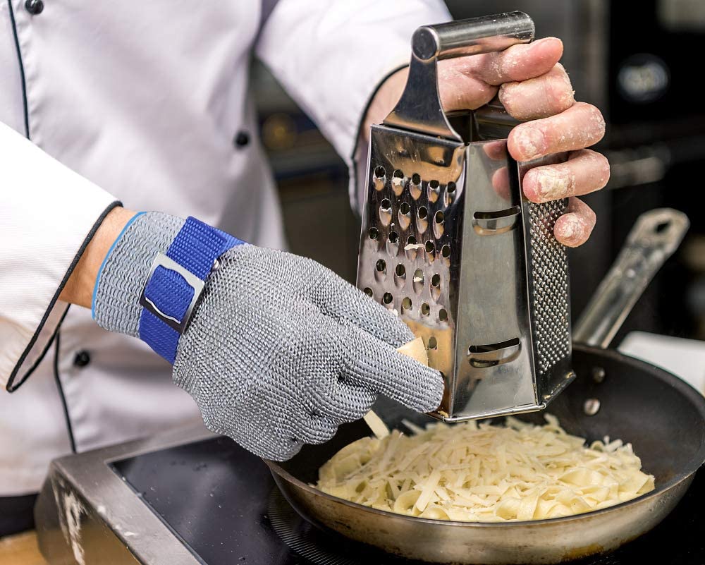 Håndverker bruker kuttbestandige industrihansker i rustfritt stål for sikkerhet og verneutstyr under arbeid.