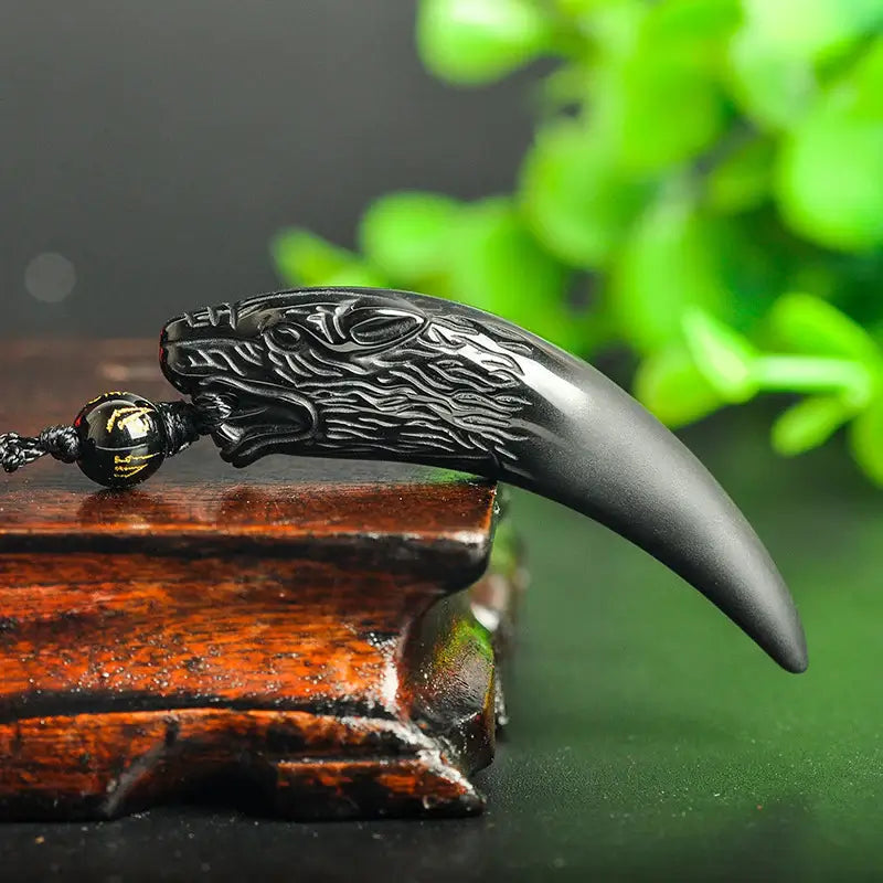 Fokus på detaljene til obsidian ulv anhenget, et unisex smykke for beskyttelse.