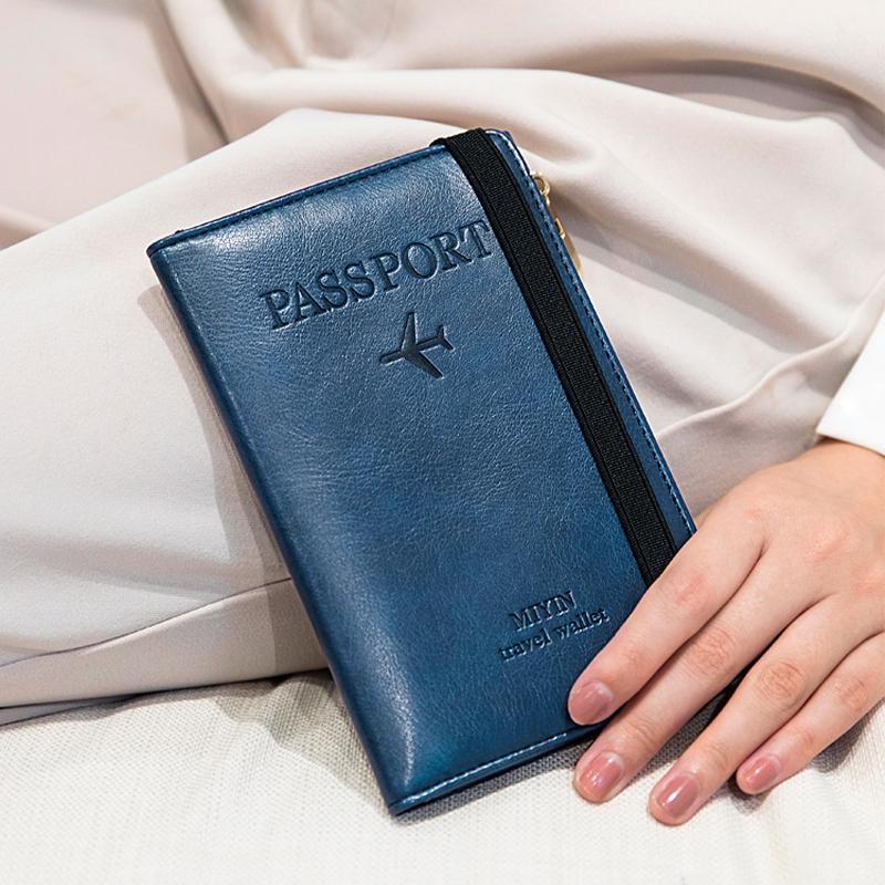 Hånd holder en stilig RFID-blokkerende passlommebok i skinn, klar for eventyr og sikkerhet.