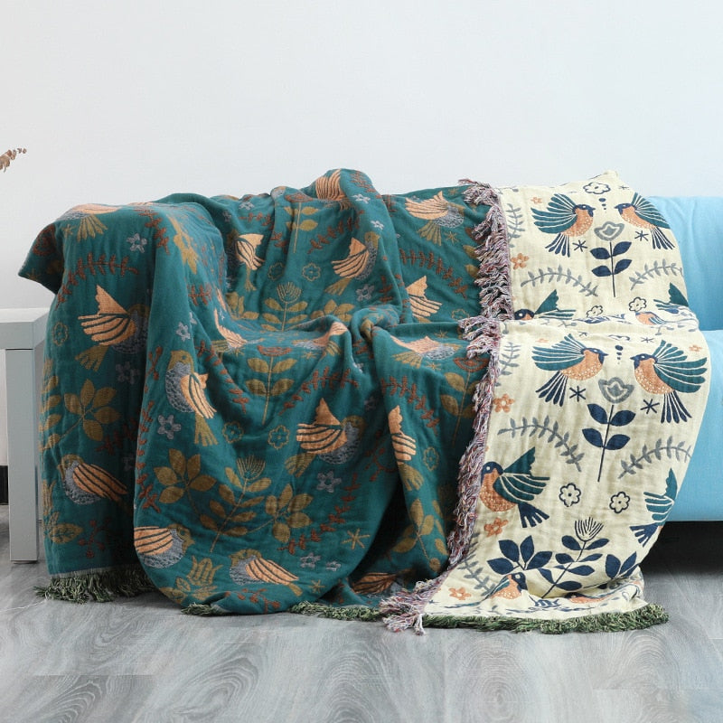 Bohemsk vintage pledd i bomull med blomster- og fugleprint. Vendbart teppe med dusker, ideelt for hjem og interiør.