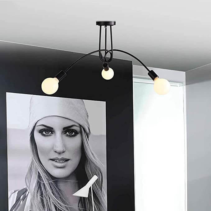 Industriell taklampe med vintage design over stuebord, skaper stemningsfull retro belysning.