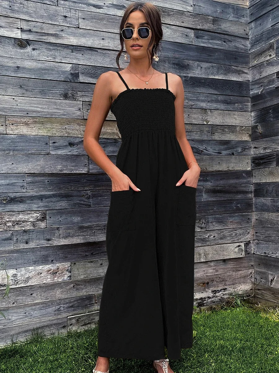 Dame i vintage sommerromper med spagettistropper, vide ben. Avslappet og komfortabel casual stil for ferie.