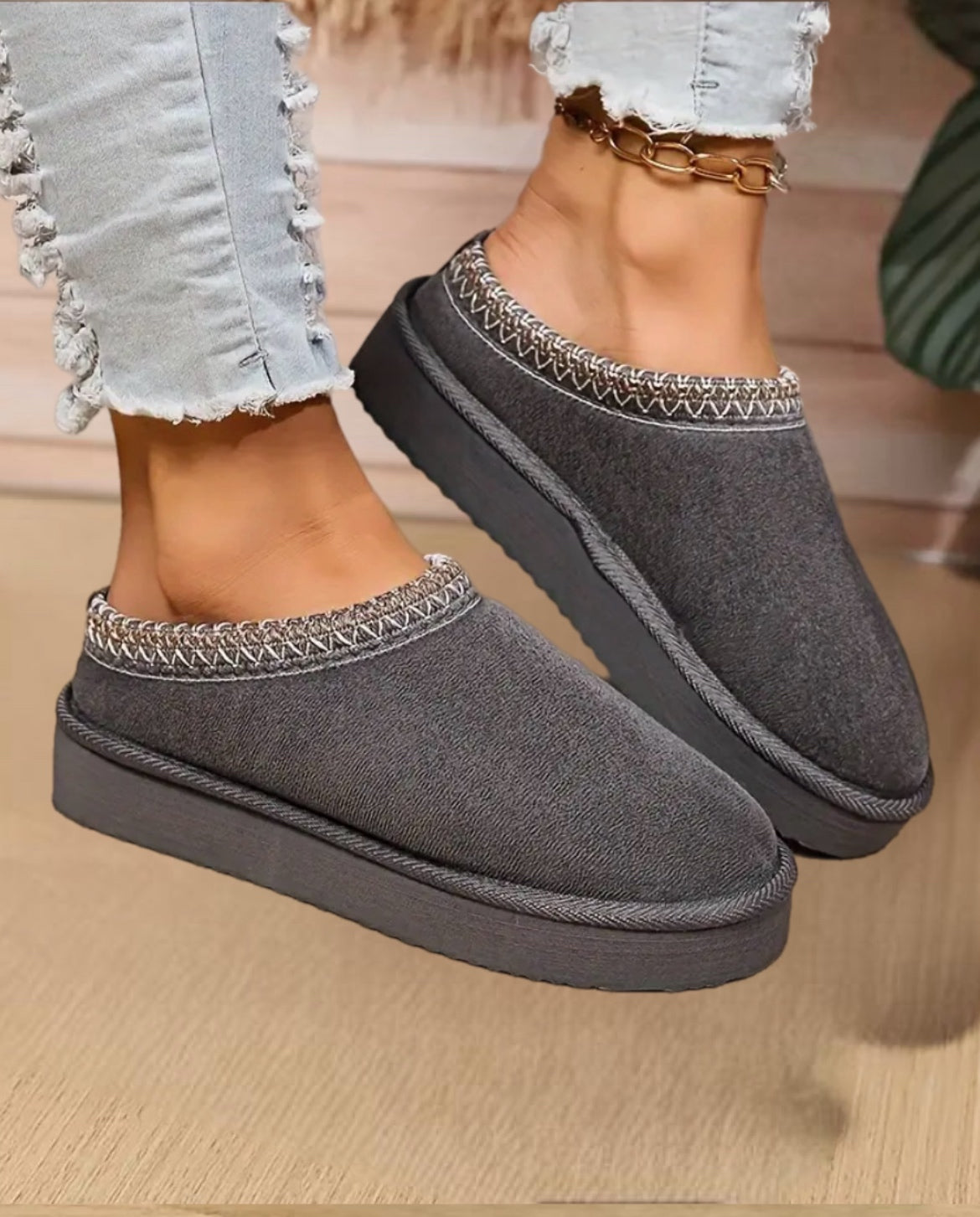 Nahaufnahme einer Frau, die flauschige warme Damen-Hausschuhe zu Hause trägt, entspannt