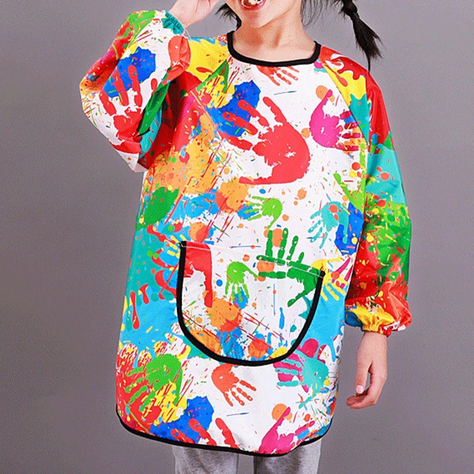 Flere flerfargede, vanntette malerforklær for barn med lange ermer, stablet, klare for kreative aktiviteter.