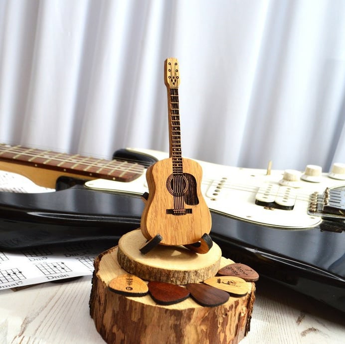 Animerte bilder av gitarplektre som blir lagret i en tre gitarplektreholder