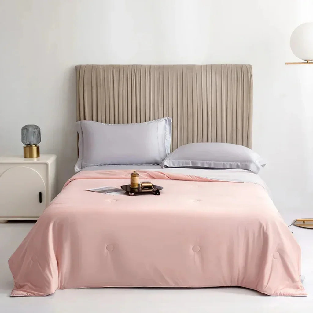 "Kühlende Sommerdecke in Himmelblau auf Bett, ideal für heiße Nächte, atmungsaktiv und hautfreundlich für erholsamen Schlaf."