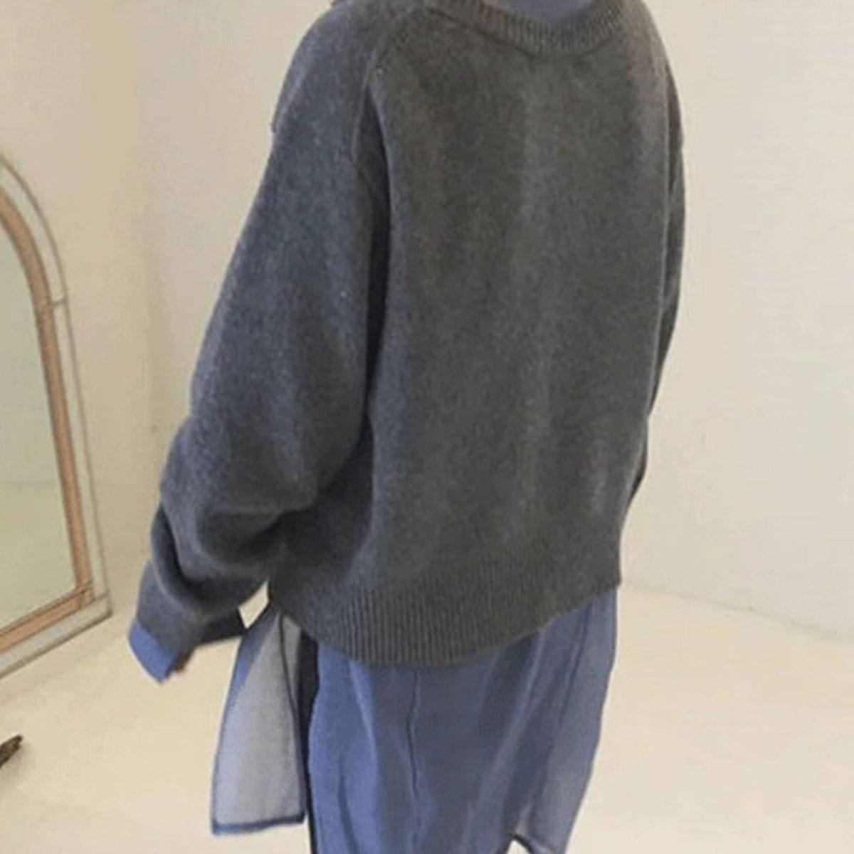 Detaljbilde av den koselige omslagsjakken og dens unike knappdesign