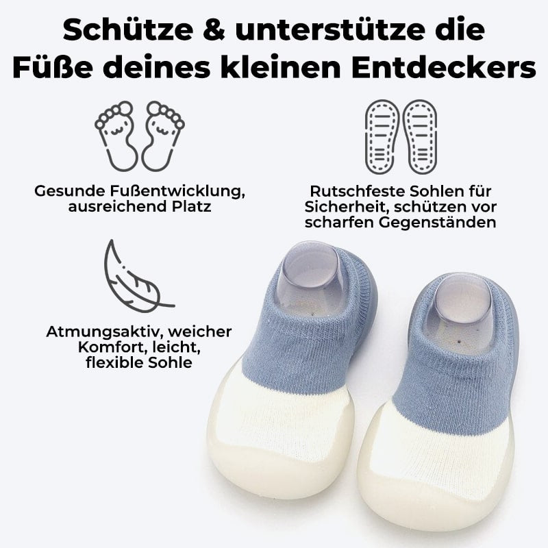 Glad baby som leker med SweetFeet barfottøfler