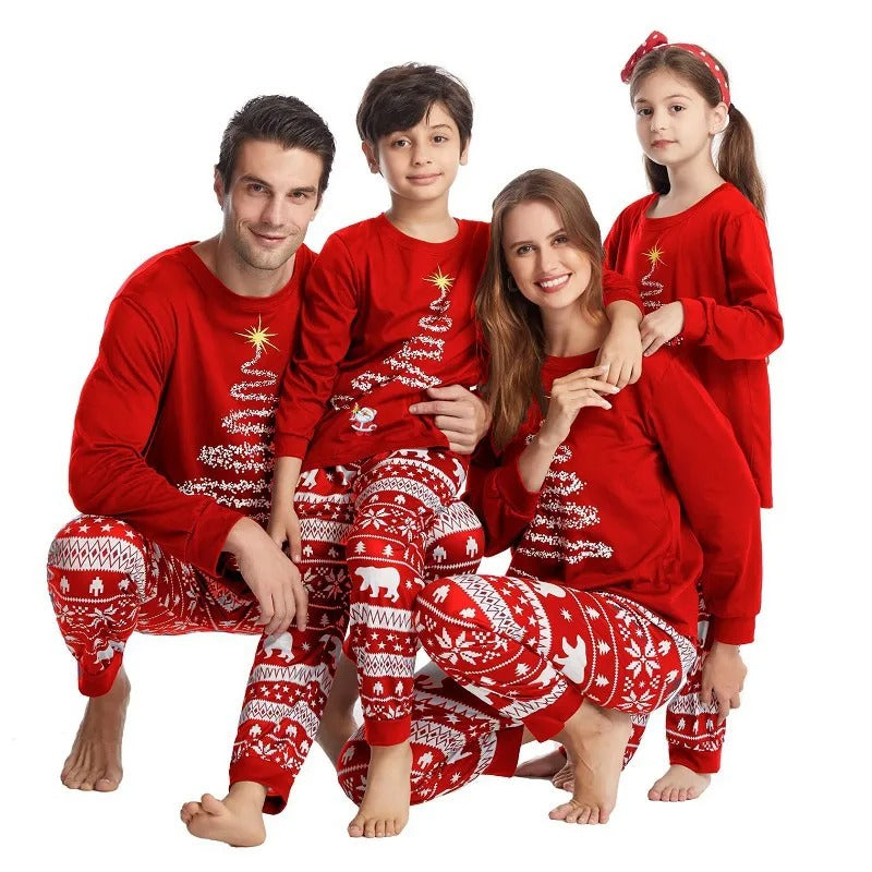 Familie i blå julepysjamas som pynter juletreet