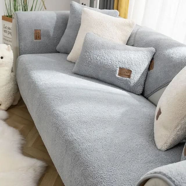"Zora Sofabezug aus weichem, luxuriösem Sherpa-Fleece in Wohnzimmer, schützt Sofa und verleiht elegante Gemütlichkeit."
