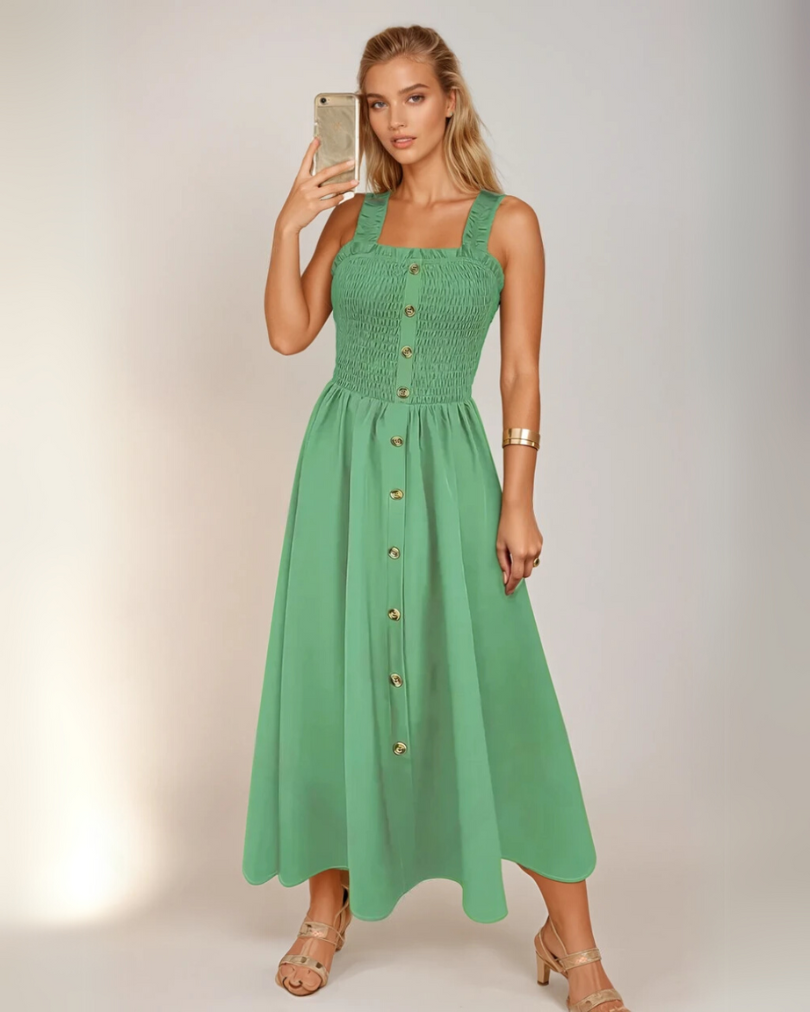 Kvinne iført elegant A-line maxikjole med shirret midje og firkantet hals. Stilfull vår-/sommerkjole.