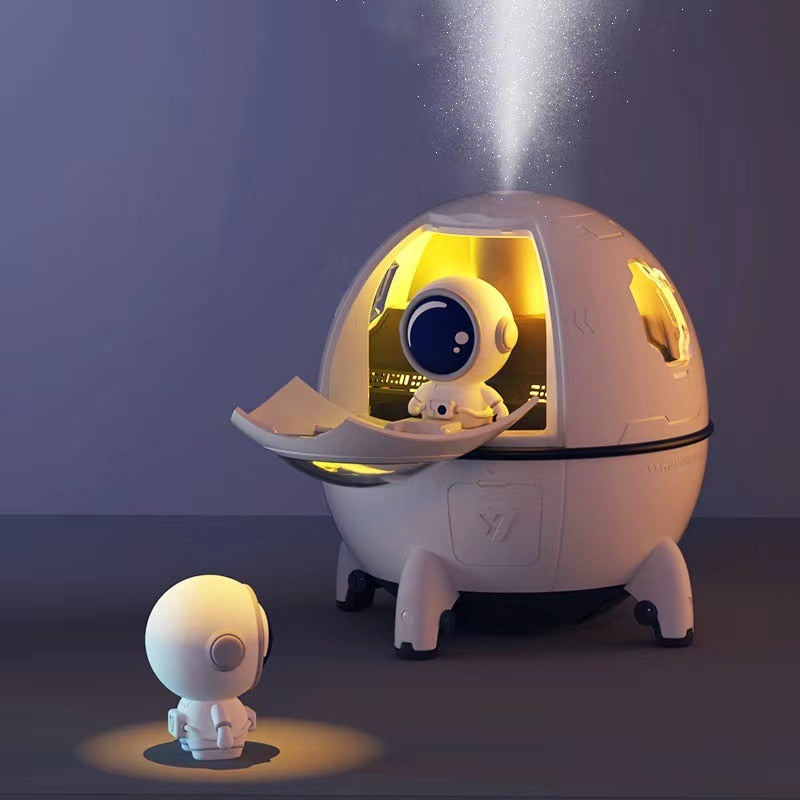 Hvit astronautfigur som fungerer som fukter, LED-nattlampe og diffuser. Skaper god atmosfære.