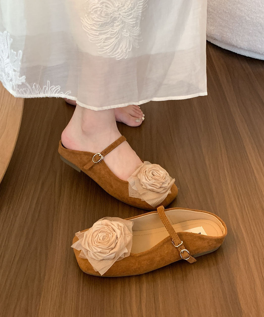 Flate damesandaler i beige med stilig blomsterdetalj, moderne og komfortable sommersko.